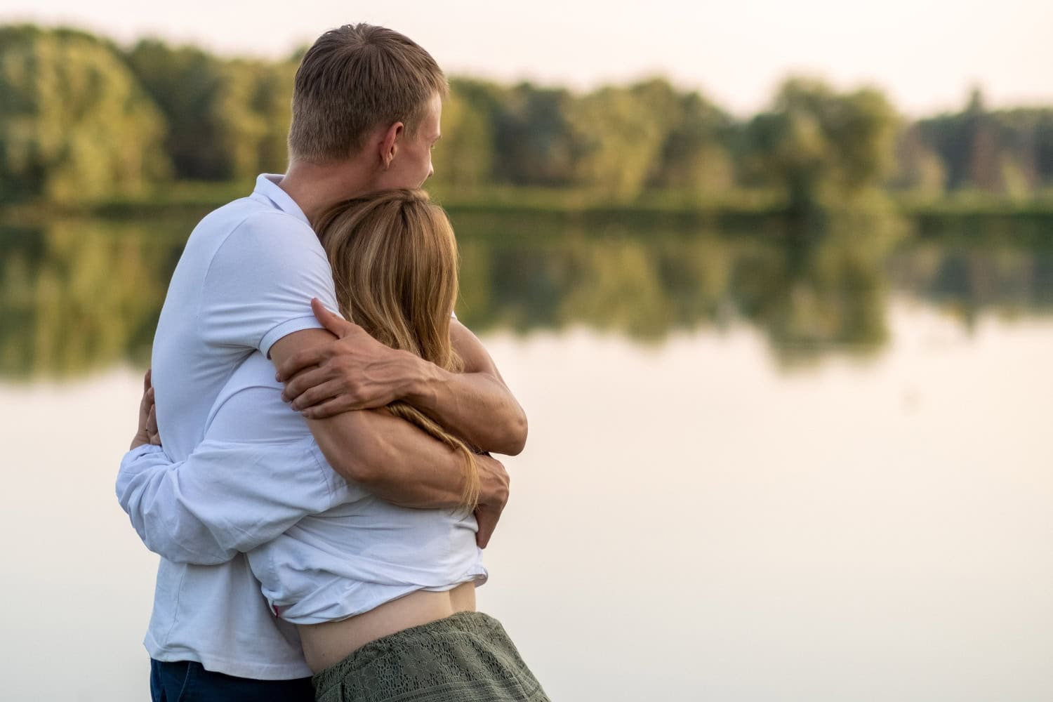 Fremdverliebt - Paar hält sich umschlungen am See,