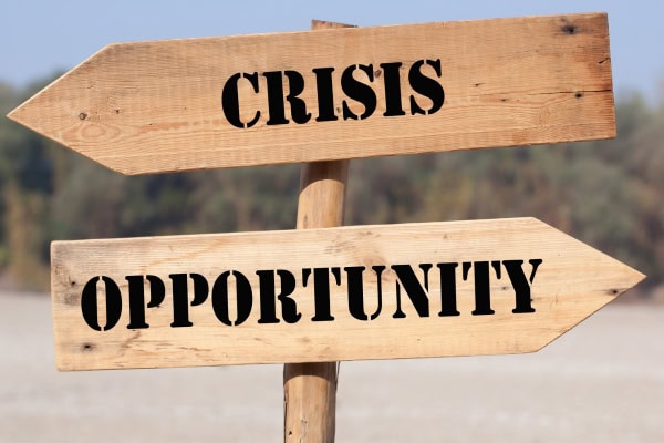 Zwei Schilder in verschiedene Richtungen: Krise und Chance